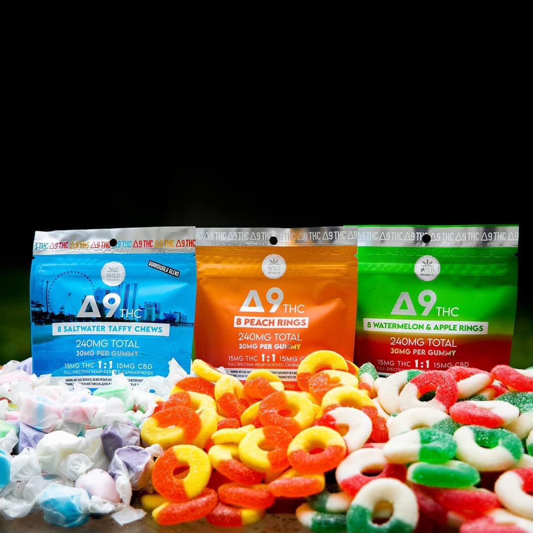 Bags of delta-9 THC and HHC-R edibles, featuring saltwater taffy, peach rings, and watermelon & apple rings, are displayed with the colorful candies spread out in front.
