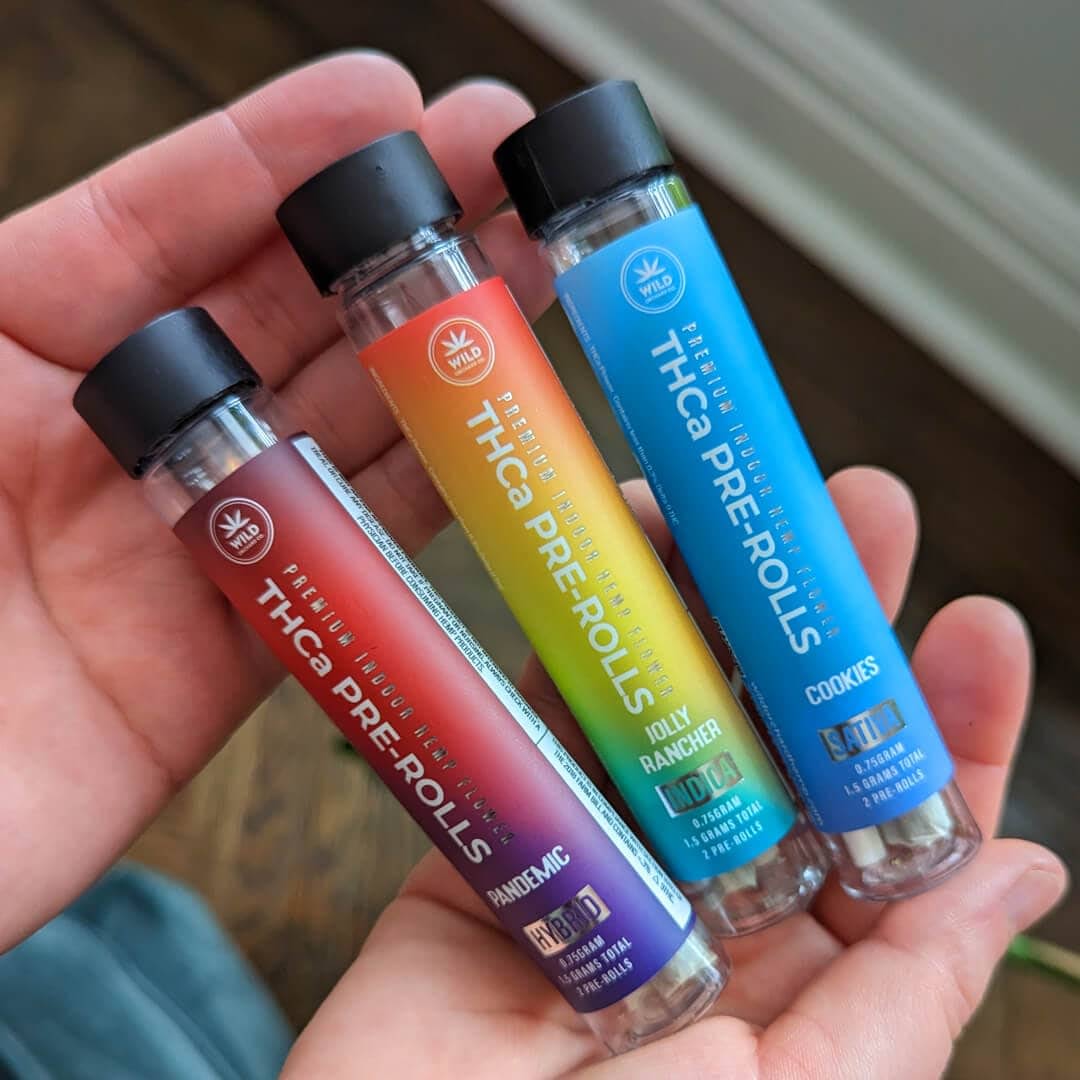Three bottles of cbd oil in a person's hand.
