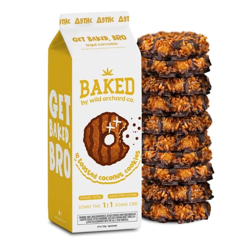 A carton labeled "Get Baked, Bro" sits by 10 toasted coconut cookies. Infused with Baked Delta-9 Peanut Bud-der, it highlights its legal cannabis content and details on THC and CBD.